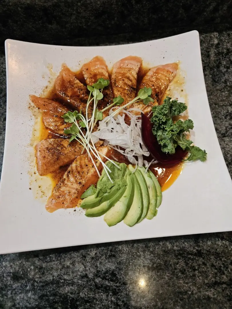 A white plate topped with meat covered in sauce.